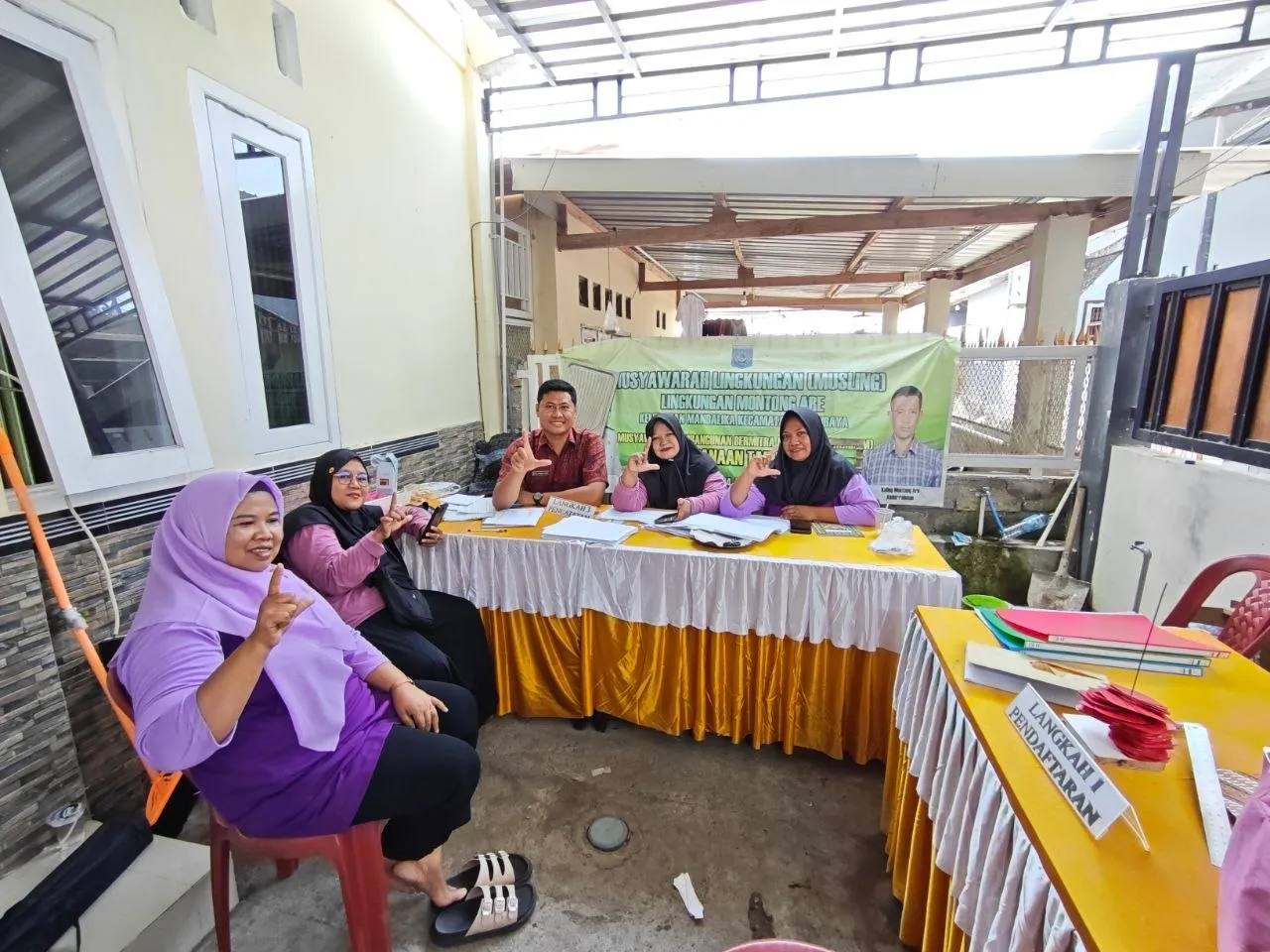 Kegiatan posyandu dengan meja pelayanan di halaman