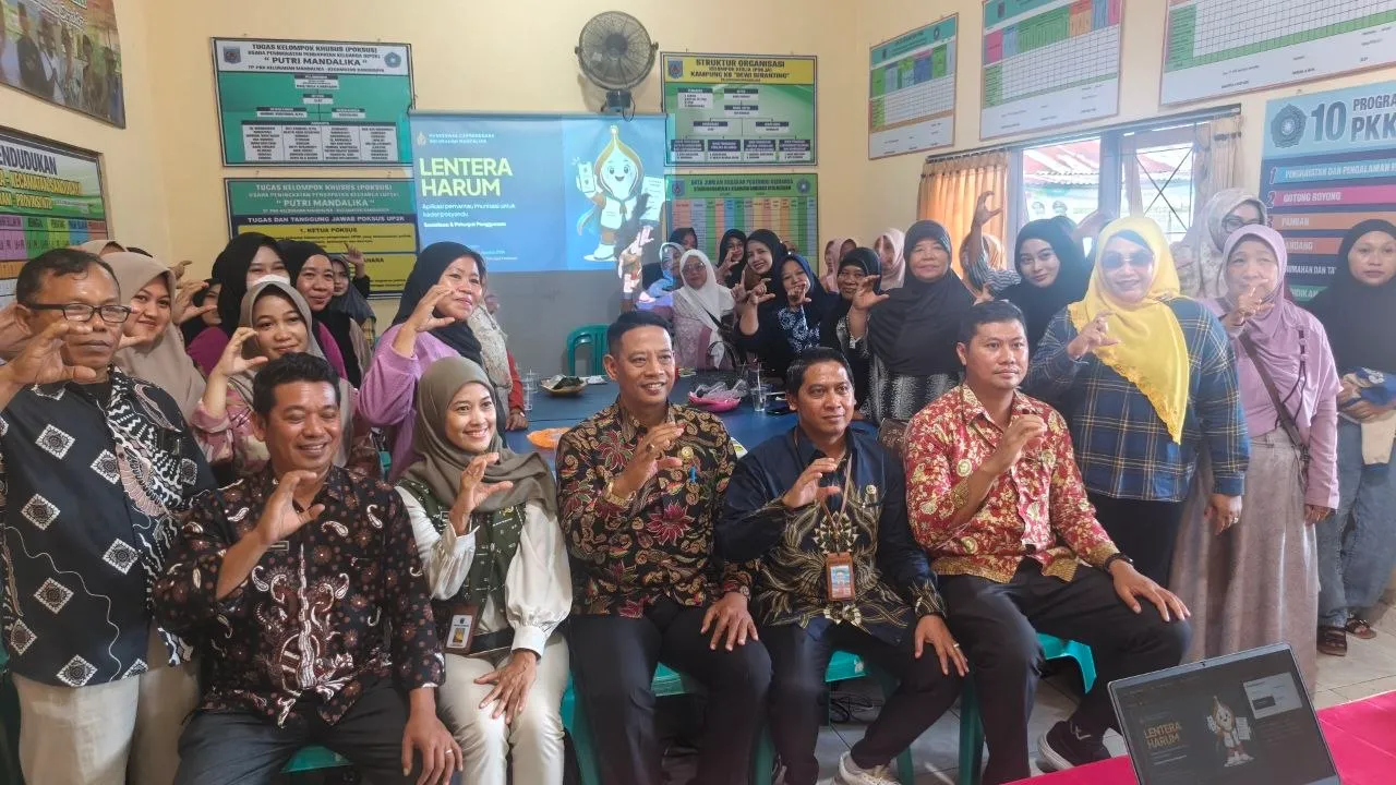 Peserta sosialisasi berfoto bersama di depan layar bertuliskan LENTERA HARUM